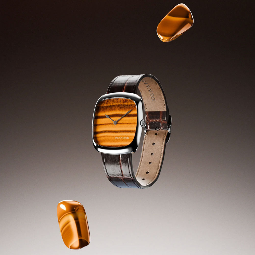 Tiger eye dial watch in steel case with brown leather strap floating against a warm gradient backdrop