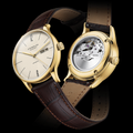 Pair of Berlin Automatic gold 38mm watches with sepia dials on brown leather straps front and back view exposing the movement