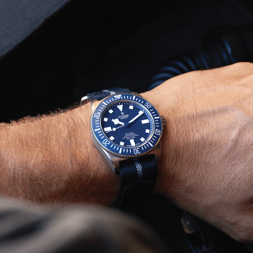 Wrist shot of Tudor Pelagos FXD 42mm with blue dial on a striped blue fabric strap
