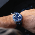 Wrist shot of Tudor Pelagos FXD 42mm with blue dial on a striped blue fabric strap