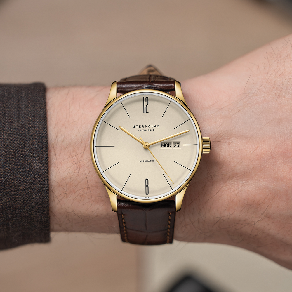 Berlin Automatic gold 38mm watch with sepia dial on brown leather strap worn on a wrist