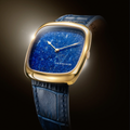 Gold 37mm watch with blue lapis lazuli dial and blue leather strap shown in a close up.