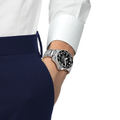 Wrist shot of a Tissot Seastar 2000 Professional on a stainless steel bracelet worn with a white shirt and navy pants
