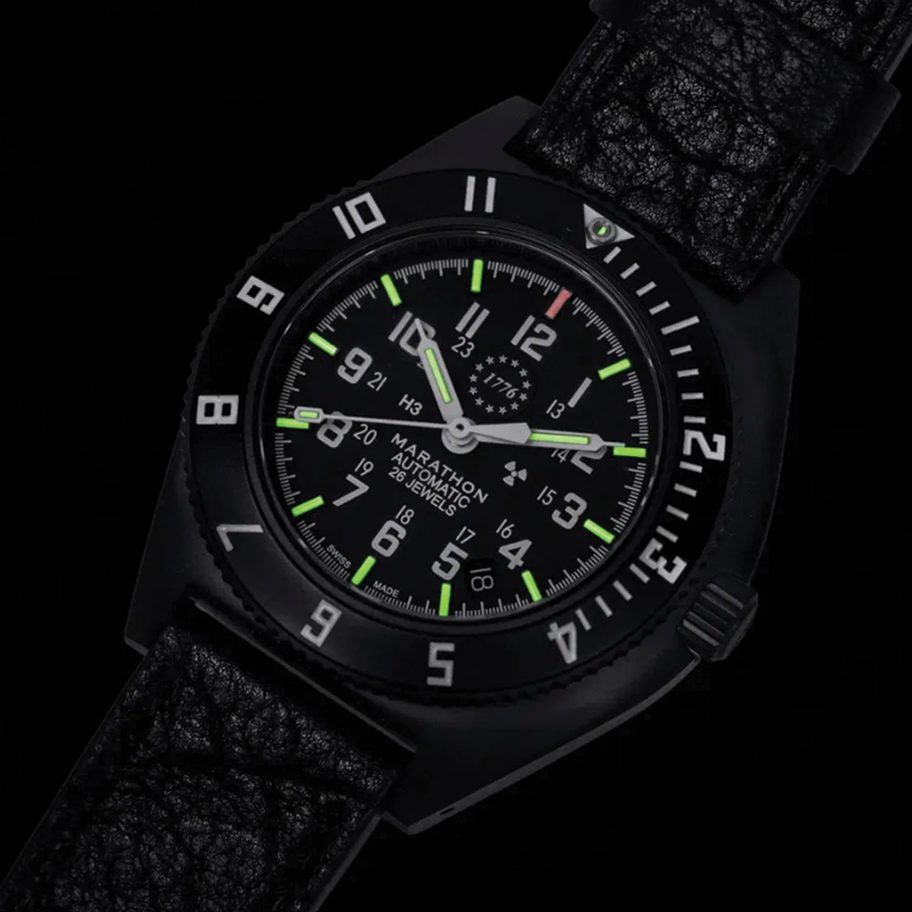 Close-up of SSNAV-D Auto U.S. 250 bezel and dial with green luminescent markers on a black rubber strap