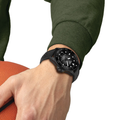Tissot Seastar 2000 professional dive watch worn on the wrist with a black textured rubber strap and a green sleeve