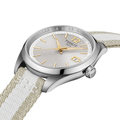 Tissot PR 100 34mm watch with grey textured dial gold hands and a beige white striped fabric strap.