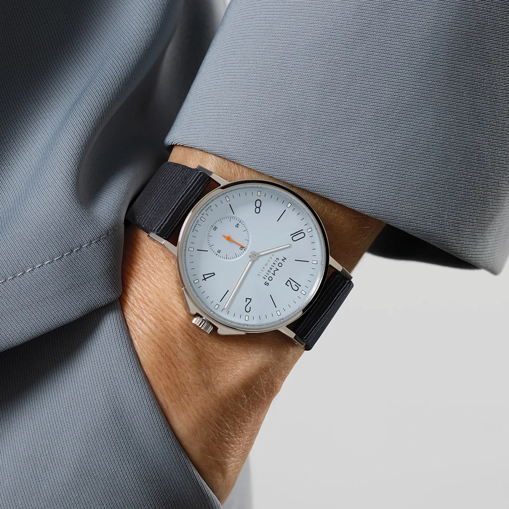 Wrist shot of Nomos Ahoi Neomatik Sky 36mm with light blue dial on a blue fabric strap.