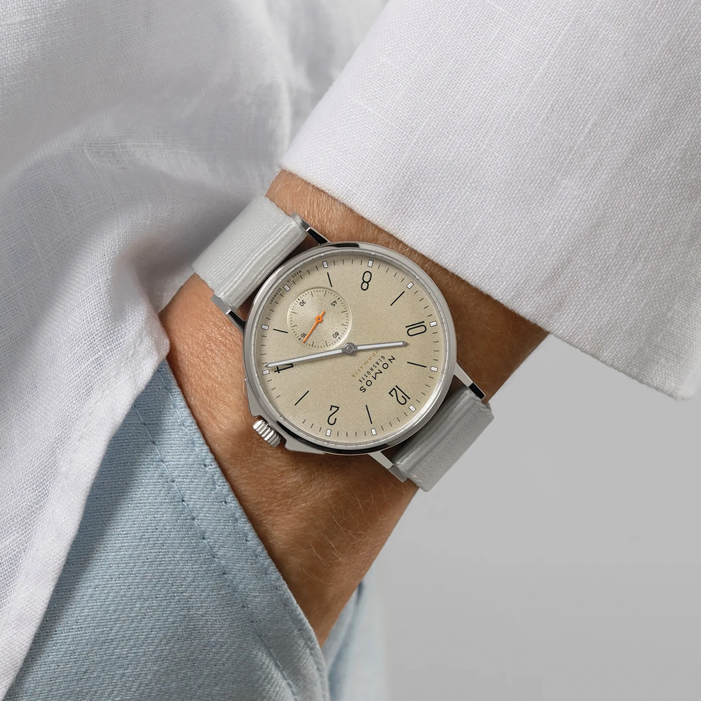 Nomos Ahoi Neomatik Sand 36mm beige dial on a light gray fabric strap worn on the wrist