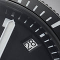 Close-up of Pelagos watch bezel showing white luminous rectangular hour markers and partial date window.
